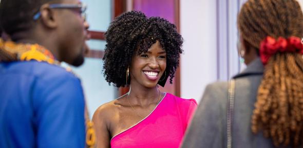 Mastercard Foundation Scholar in pink dress smiling